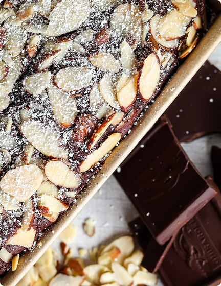 Chocolate biscuit coffee cake topped with a buttercream and powder
